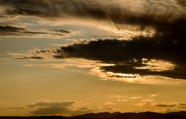 Dramatic sunset sky with dark clouds.