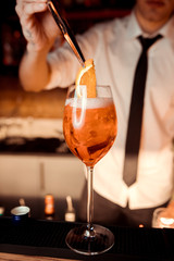 hands of the barman who poured apelol into glasses