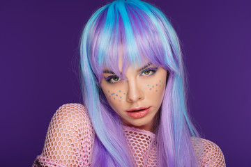 beautiful sensual girl posing in violet wig with stars on face, isolated on purple