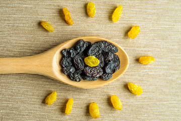 Blue Raisins in wooden spoon and anise on textile background on the kitchen.Composition in the form of sun or light bulb. symbol of idea or thought, raisins useful for brain. Healthy snack, Vega Food