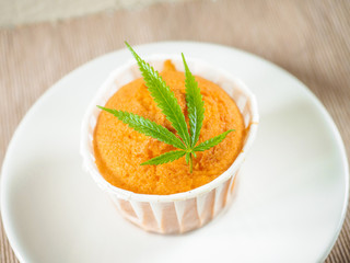 Delicious homemade baked cinnamon muffins with marijuana leaf garnish. Cookies with cannabis and buds. Treatment of medical marijuana for use in food.