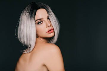 Naklejka premium beautiful stylish young woman posing in grey wig, isolated on black