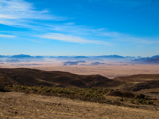 beautiful view of the rocky brown and blue mountains against the bright blue sky.