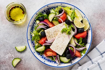 Foto op Canvas Traditional Greek Salad. Vegetarian dish with fresh lettuce, olives, peppers, cucumbers, onions and feta cheese. On light rustic concrete background. Top view. © kasia2003