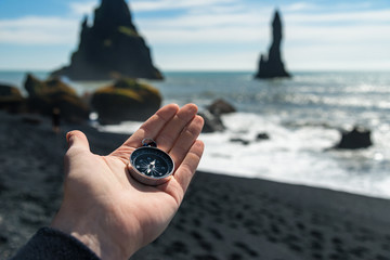 Traveler holding compass in south Iceland