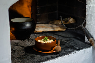 Ukrainian porridge in a clay bowl on the background of the oven