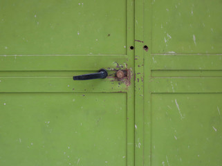 green iron garage door with handle and lock