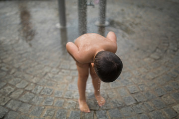 little boy take shower on swimingpool