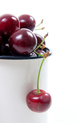 White cup with red sweet cherry isolated on a white background..