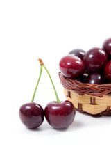 Yellow wooden basket with red sweet cherry isolated on a white background..