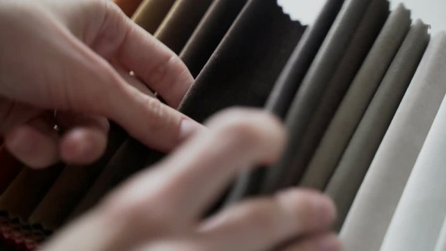 Interior designer selects fabric samples. Designer at work. Architect desk. Decoration. Decorative material. Flatlay. Woman chooses from a palette of designer velvet dark shade