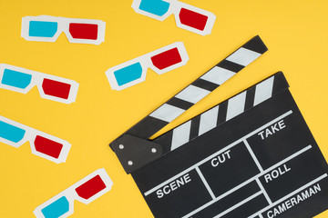 Fototapeta na wymiar plastic 3d glasses and clapperboard isolated on yellow