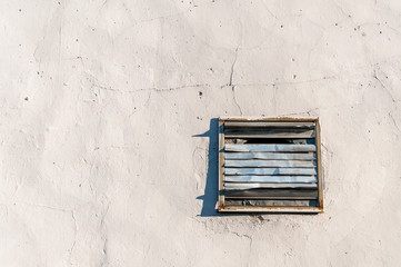 Old damaged rusty vent cover plate with grid on the wall of house or building for fresh clean air ventilation with free space