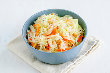 Bowl with fermented cabbage on napkin