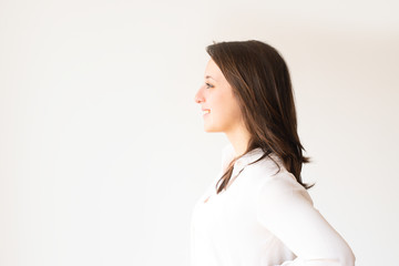 Profile portrait of smiling student in white blouse looking aside. Side view of cheerful young manager looking away. Isolated on white. Beauty concept