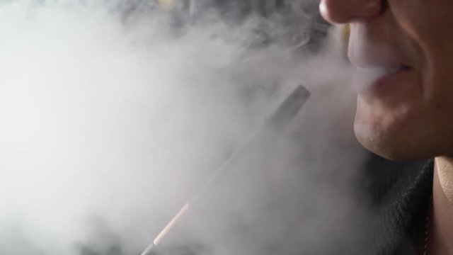 Hookah smoker. Young man smoking shisha or hookah in cafe or bar. Resting in shishabar lounge.