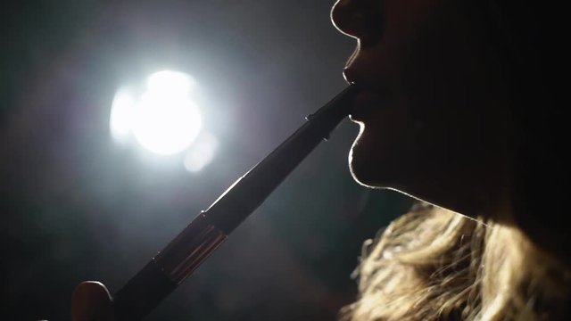 Hookah smoker. Young woman smoking shisha or hookah in cafe or bar. Resting in shishabar lounge.