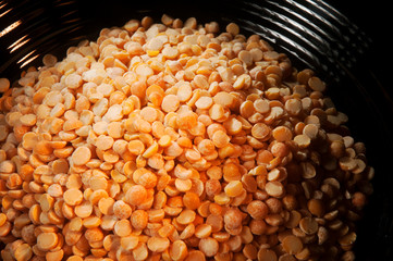 Close up of yellow split peas in a black bowl