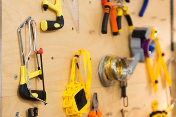 pliers, saw and other workshop tools on wall board.