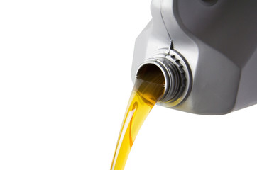 pouring motor oil from silver plastic gallon bottle isolate on white background, yellow hydrocarbon petroleum liquid in grey canister.