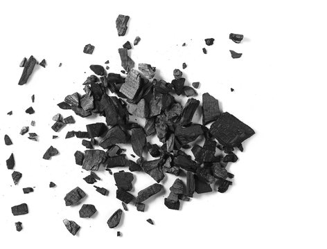 Black charcoal pile isolated on white background, top view