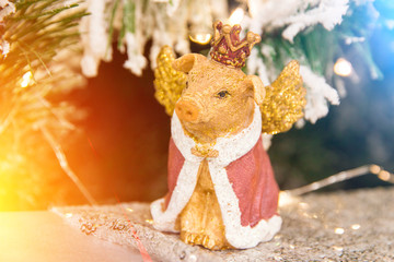 Christmas, new year decoration golden yellow pig in the crown statuette close up	