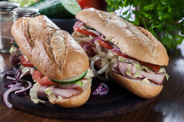Submarine sandwiches with ham, cheese and vegetables
