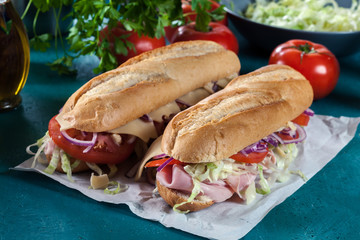 Submarine sandwiches with ham, cheese and vegetables