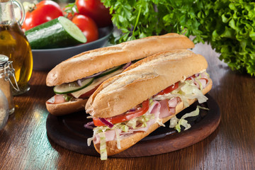 Submarine sandwiches with ham, cheese and vegetables