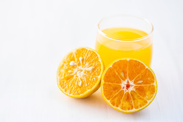 Fresh tangerine orange fruit and juice on white table