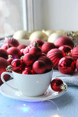 Christmas card. Beautiful Christmas background. Lots of red balls big and small on blue texture background. White snowflakes circling, the effect of falling snow. Copy space.