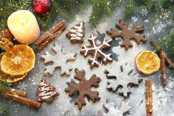 Postcard Christmas cookies in the form of flakes, decorated with dried orange, cinnamon sticks and anise, the background is sprinkled with flour. Copy space.Tinted effect.