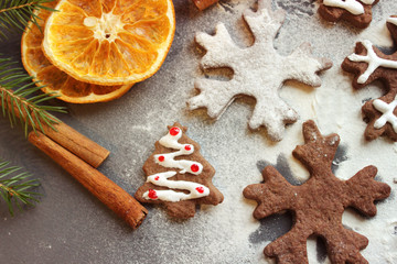 Postcard Christmas cookies in the form of flakes, decorated with dried orange, cinnamon sticks and anise, the background is sprinkled with flour. Copy space.Tinted effect.