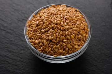 seeds of golden flax on a dark stone background