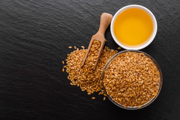 seeds of golden flax on a dark stone background
