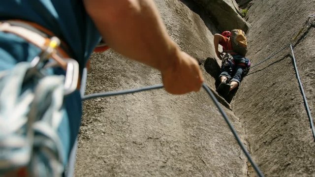 Climber belaying on rock face in Squamish Canada