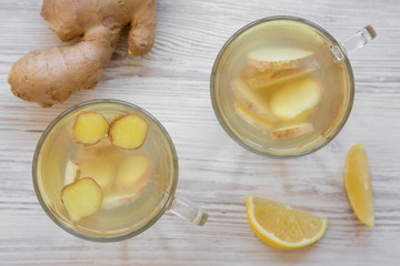 Homemade ginger tea with lemon on white wooden table, overhead view. Close-up. Flat lay, from above, overhead.