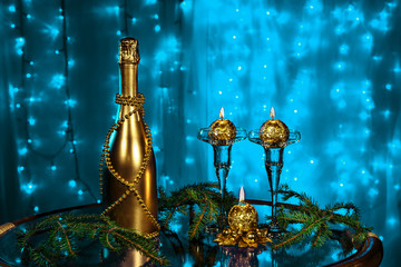 A bottle of champagne and candles in New year and Christmas on blue background