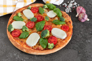 Pizza, food, vegetable, margarita.  Vegetables, mushrooms and tomatoes pizza on a black wooden background. It can be used as a background