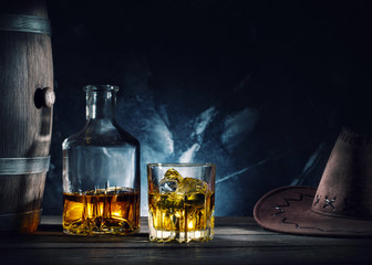 Whiskey and hat and barrel on dark background