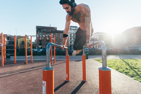 Man using parallel bars in outdoor gym
