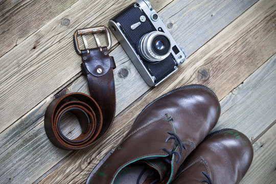 sturdy brown boots, leather belt, and rangefinder camera