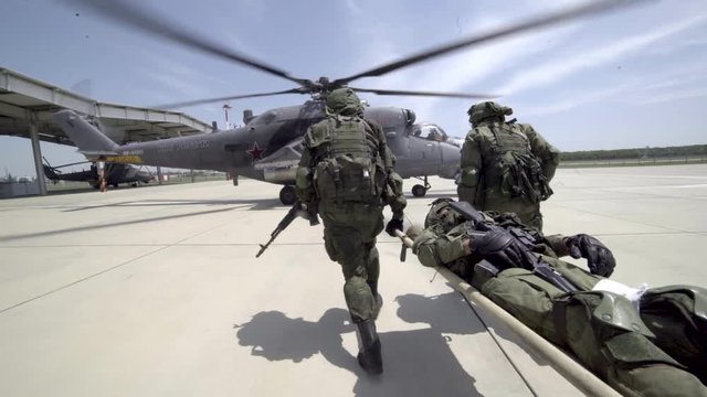 Russian special forces soldiers evacuate a wounded soldier by helicopter MI-35m (Hind).