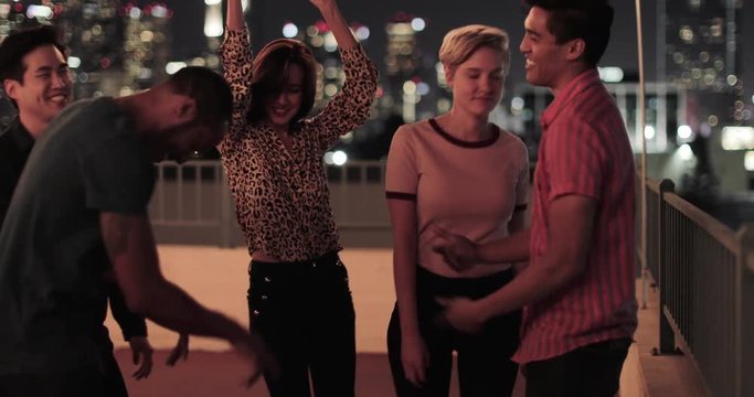 Group of friends dancing at a rooftop party