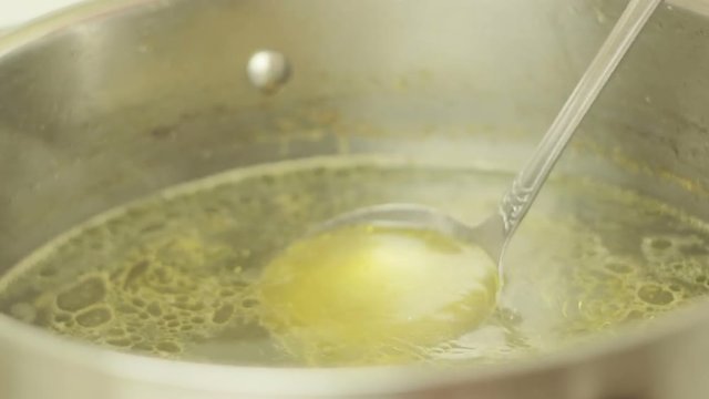 Rich Chicken Bouillon In A Saucepan Stirred By The Ladle