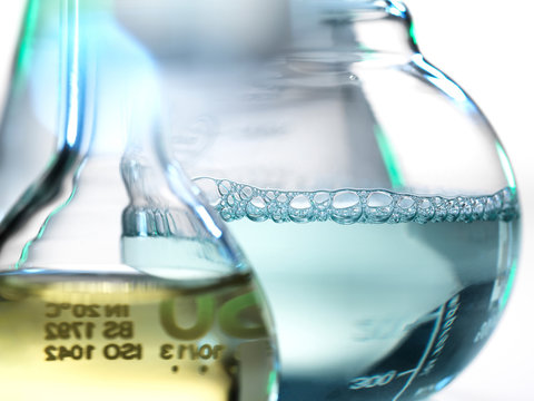 Laboratory beakers containing chemical formulas