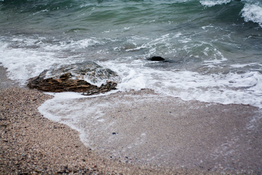 Pebbles on the beach, close up, sea waves on the background