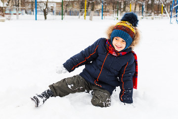 Fototapeta na wymiar cheerful boy playing in the snow in the open air