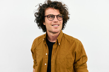 Outdoor shot of handsome curled hair and smiling man wears spectacles posing for social...
