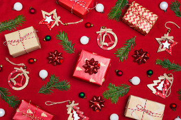 Christmas composition of gifts  and decoration on red fabric background.
